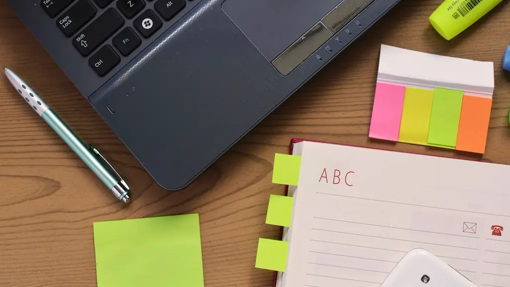 Laptop with sticky notes and a planner