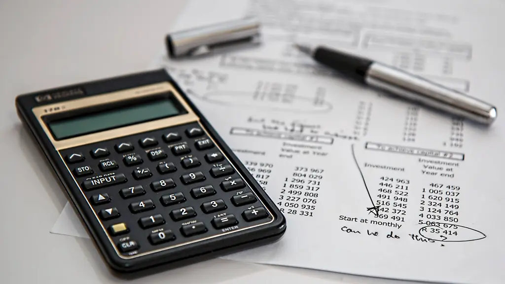 Calculator and pen on printed financial figures