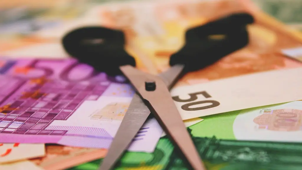 Scissors cutting through euro banknotes